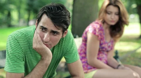 Relationship difficulties, couple sitting in park, steadicam shot HD Video stock 11819938