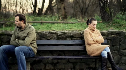 Relationship difficulties, young couple sitting on bench in the park Stock Footage 943723