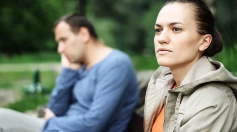 Relationship difficulties, young couple sitting on bench in the park HD Stock Footage 6983994