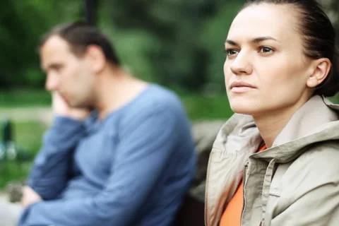 Relationship difficulties, young couple sitting on bench in the park NTSC Stock Footage