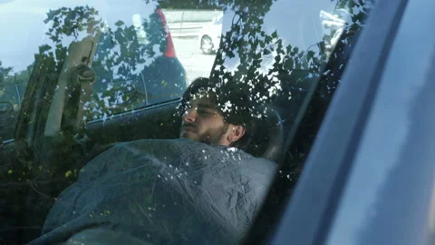 Relationship problems - man who left home after a fight sleeps in the car  Stock Footage 154130386