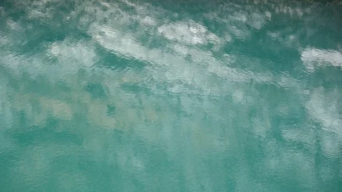 Relatively calm turquoise water. Surface of lake reflects mountains. Stock Footage 109812068