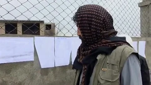 Relatives search for missing persons on lists posted on the wall of the Kabul ho 库存影片 330956580