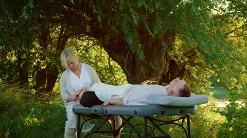 Relax and restorative massage procedure at nature. Man lying on couch enjoying Stock Footage 313676953