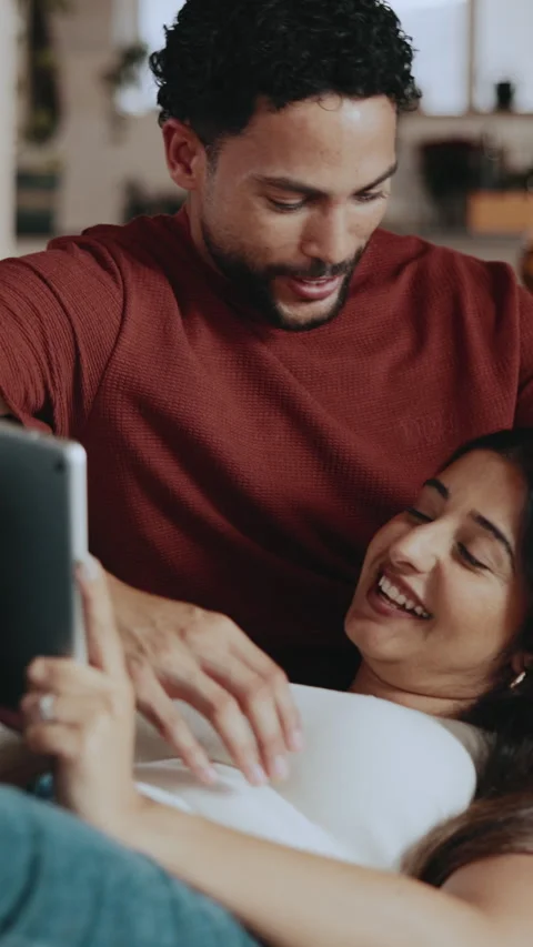 Relax, couple and laugh on sofa with tablet, deal hunting and create wishlist Stock Footage 346236021