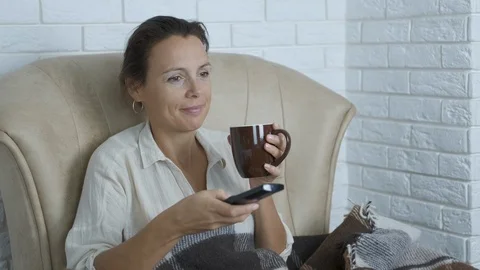 Relax with cup of tea by TV. Vídeos de archivo 117194175