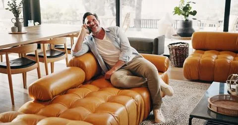 Relax, man and laugh on sofa with phone call, friendly chat or funny gossip.. Stock Photos