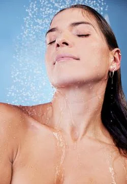 Relax, refresh, renew. Studio shot of a young woman taking a shower against a Stock Photos