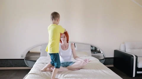 Relax on your bed. The child interferes with yoga. Mom is tired of homework. Day Stock Footage 156300850