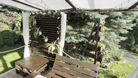 A relaxation area in the garden in front of the house, a wooden veranda, a .. Stock Footage 314485170