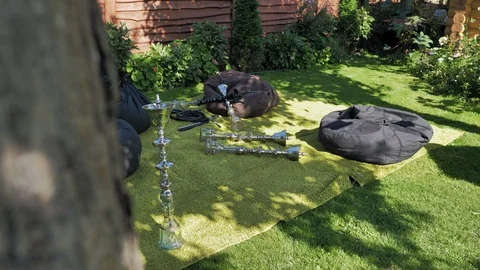 Relaxation area with hookahs and puff chairs outdoors on a summer sunny day. Stock Footage 128598039