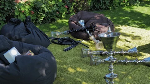 Relaxation area with hookahs and puff chairs outdoors on a summer sunny day.  Stock Footage 128598151