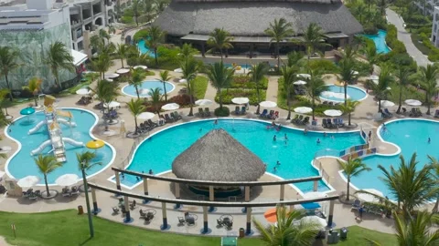 Relaxation area with pool, cafe, palm trees, and sun loungers. Stock Footage 159672140