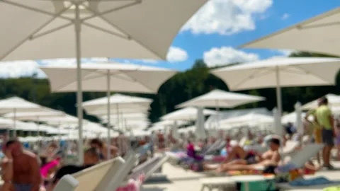 Relaxation area by the pool with plenty of sun loungers and parasols.  Stock-Footage 318973333