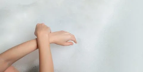 Relaxation, reflection, thoughtfulness in a bubble bath concept. Women's hand Stock Photos