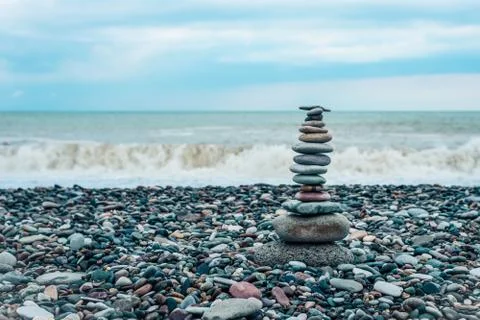Relaxation at sea. Stack of stones on beach - nature background. Stone cairn Stock Photos