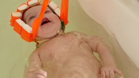 Relaxed 3-4 months boy bathing in bathroom Stock Footage 75444860