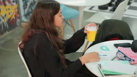 Relaxed Asian student engaged in learning with coffee and gadgets. Casual study Stock Footage 328156685