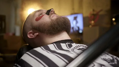 Relaxed beard man in barber chair with cleansing strip for nose and eye patches. Stock Footage 235561663