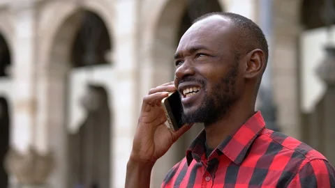 Relaxed black man talking by smartphone in the street Stock Footage 87400912
