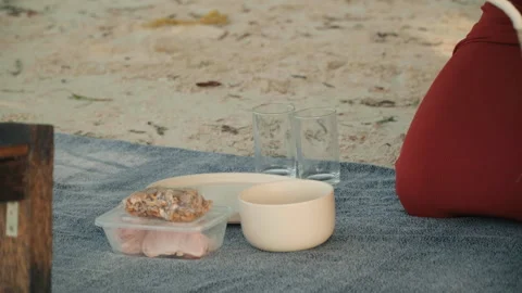 Relaxed boho picnic featuring tea cups and scenic shoreline view. Gentle Stock Footage 333566877