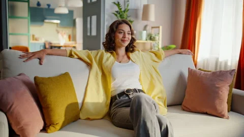 Relaxed brunette falling couch enjoying modern interior living room. Happy woman Stock Footage 333312732