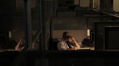 Relaxed business man working late at the office in cubicle Stock Footage
