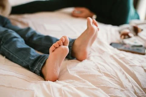 Relaxed Child Lying on Bed with Bare Feet Showing Stock Photos