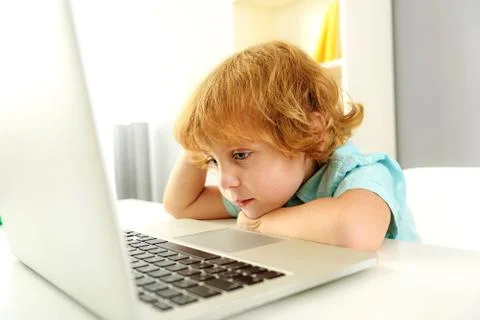 Relaxed child sitting with computer Stock Photos
