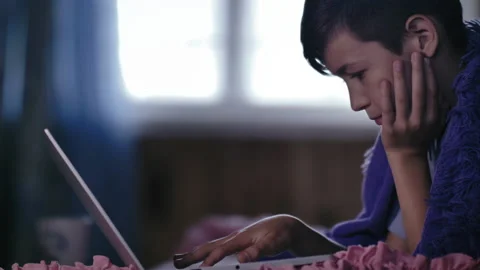 Relaxed Computing: Close-Up of a Boy Aimlessly Clicking Keys on Laptop with Stock Footage 239585100