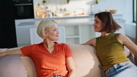 Relaxed couple falling sofa in modern apartment closeup. Young women giving five Stock Footage 335156634