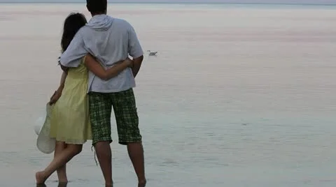 Relaxed couple looking at the birds floating on the sea Video stock 12272986
