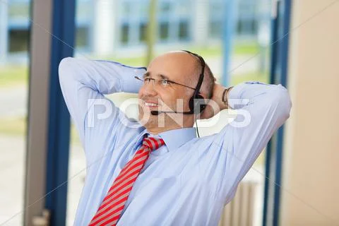 Relaxed customer service executive with hands behind head Stock Photos