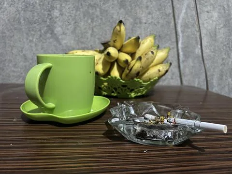 Relaxed drinking coffee and eating bananas Stock Photos