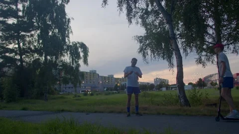 Relaxed evening scene featuring friends exercising at dusk in park Stock Footage 324591938