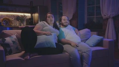 Relaxed fat couple watching TV at home h... | Stock Video | Pond5