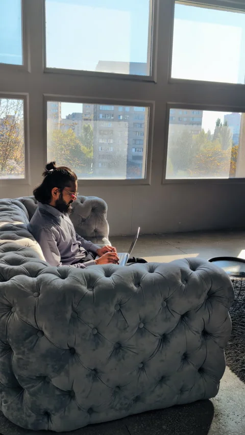 Relaxed Indian IT CEO sitting on stylish couch, working online from home office Stock Footage 316838934