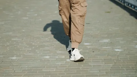 Relaxed individual crossing urban structure. Sunlit scene of pedestrian moving Stock Footage 334946759