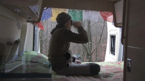 Relaxed man in the camper drinks a cup of coffee Stock Footage 98041218