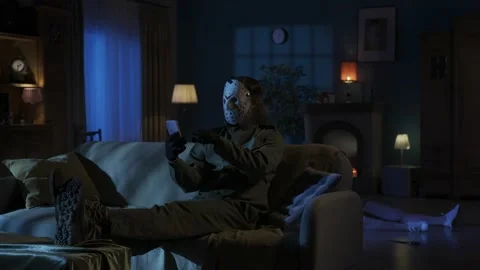 Relaxed man maniac sitting on the sofa in the someones living room, legs up on Stock Footage 250008938