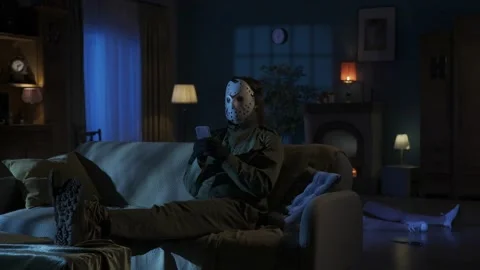 Relaxed man maniac sitting on the sofa in the someones living room, legs up on Stock Footage 250009022