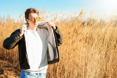 A relaxed man opens his jacket to feel the sun on the first warm spring day.. Stock Photos