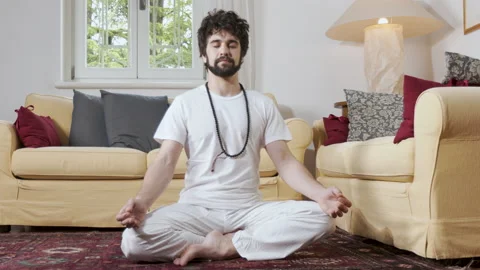 Relaxed Man Practicing yoga sitting Indoor, focusing on meditation Stock Footage 130186616