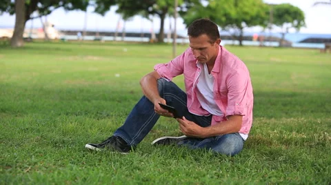 Relaxed Man Reading eBook In The Park Stock Footage 55584015