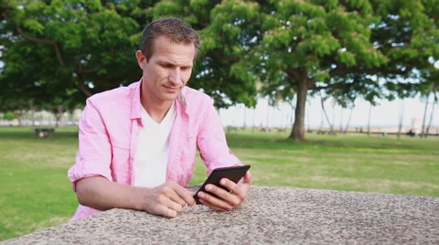 Relaxed Man Reading eBook In The Park Stock Footage 55620801