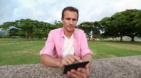 Relaxed Man Reading eBook In The Park Stock Footage 55620869