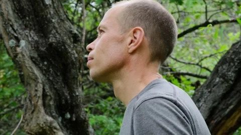 Relaxed man spending time outdoors. Portrait of guy enjoying walk in the forest. Stock Footage 269675228