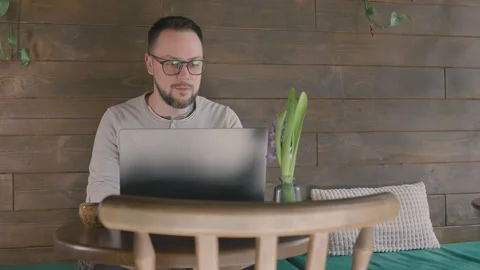 Relaxed man studying at the modern cafe, typing on keyboard, sitting on comfy 스톡 동영상 270182877