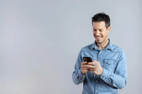 Relaxed Man using phone in studio shot, copy-space. Stock Photos