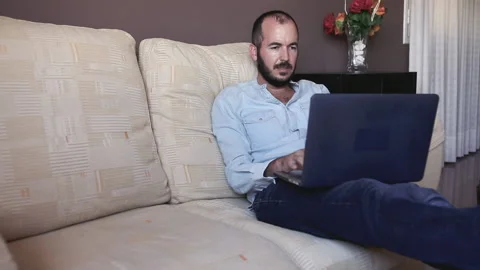 Relaxed man working with a computer from home Stock Footage 130878811